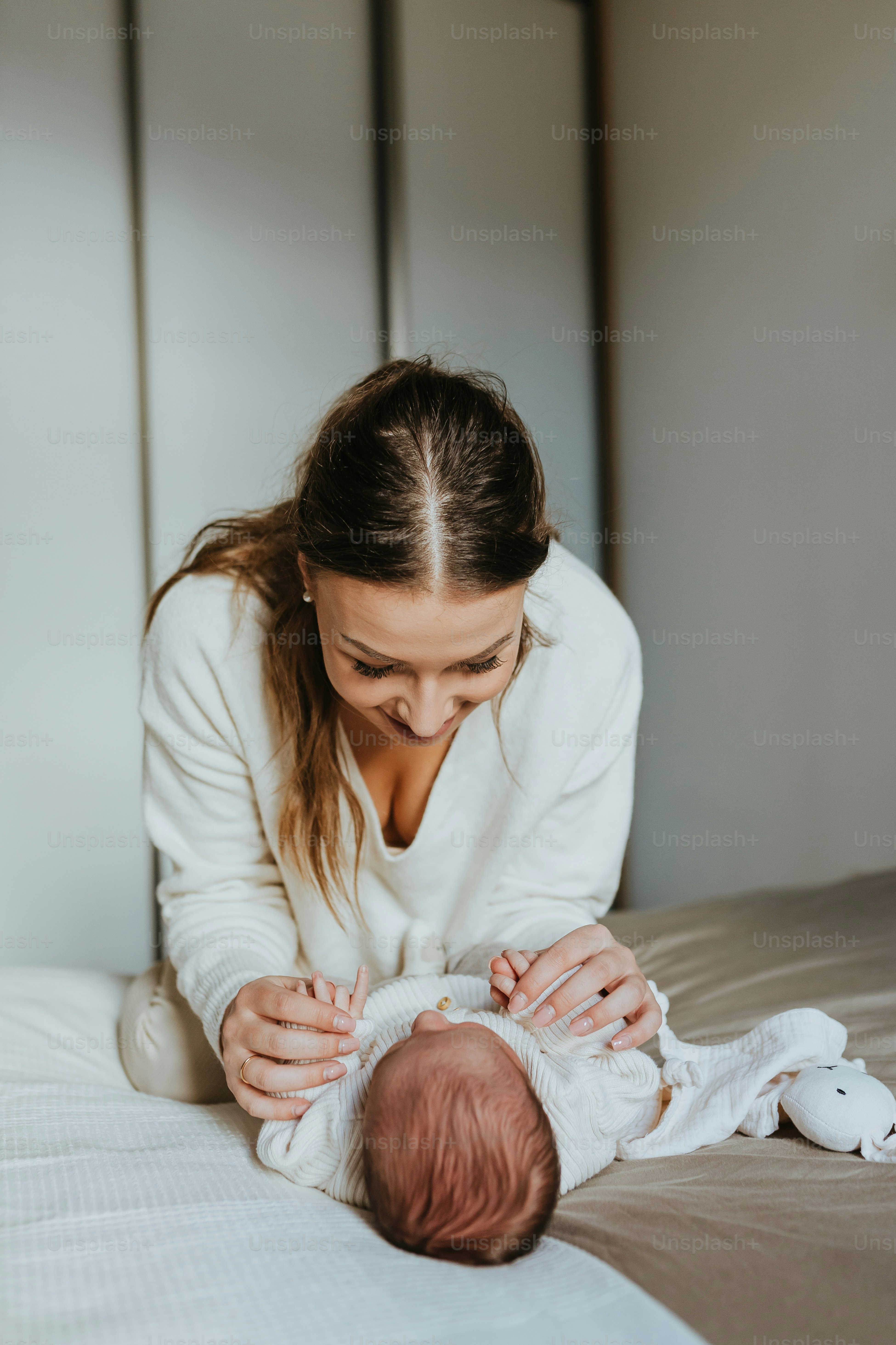 seorang wanita menggendong bayi sambil berbaring di tempat tidur