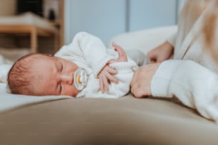 un bébé allongé sur un lit avec une sucette dans la bouche