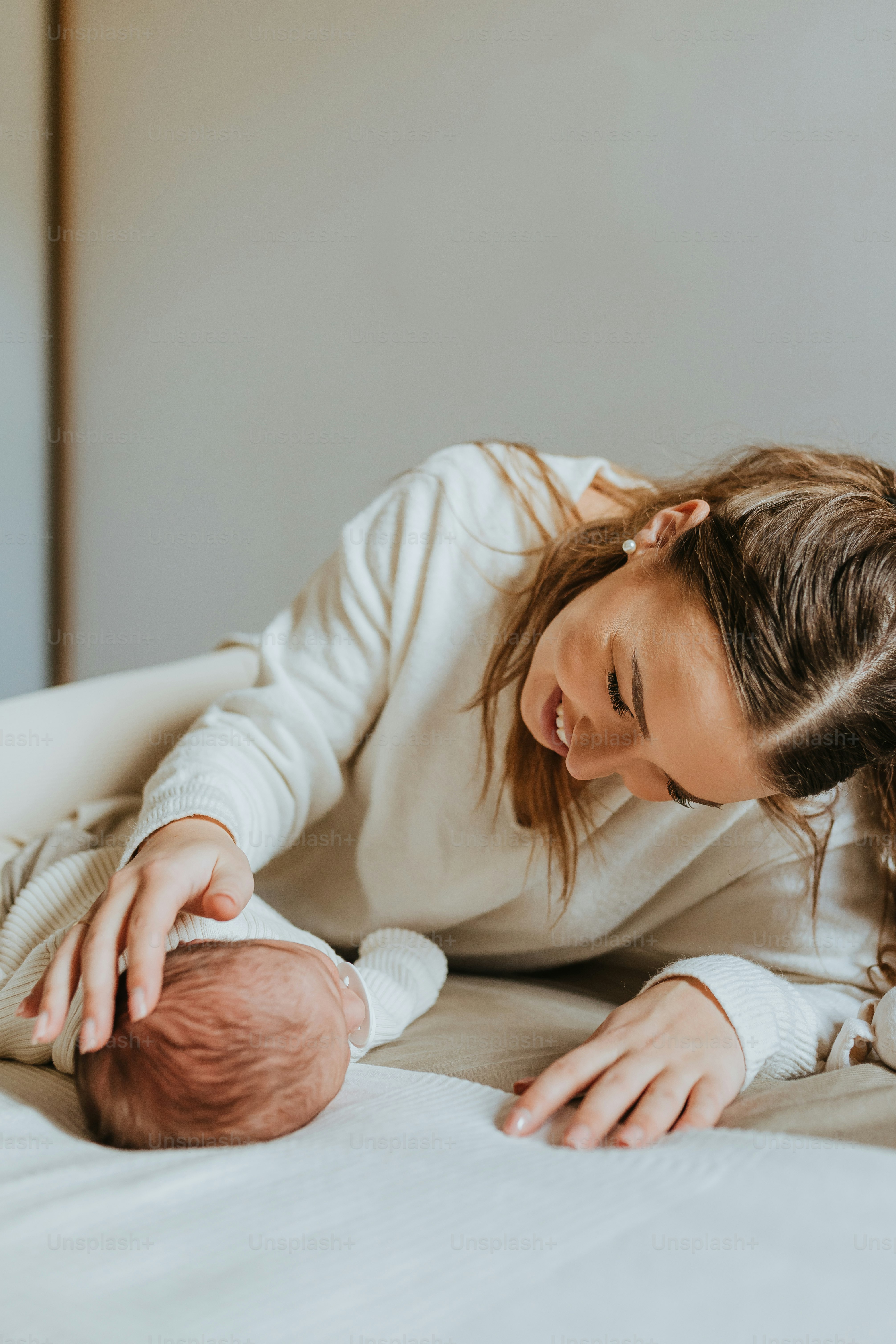 a woman holding a baby on a bed