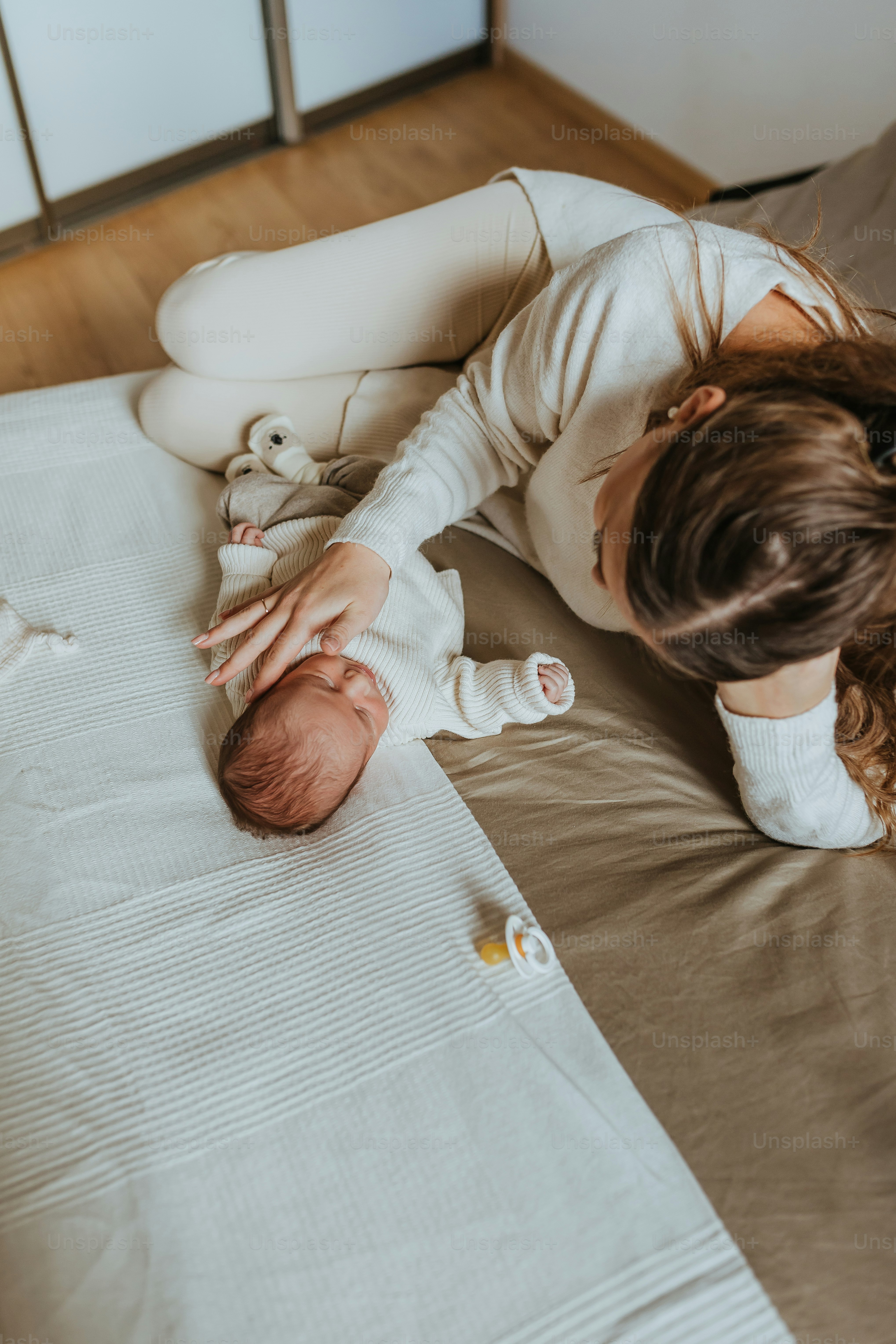 a woman laying on a bed holding a baby
