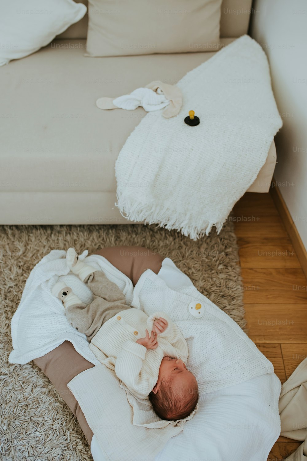 Foto Un bebé acostado encima de una manta en el suelo – Bebé Imagen en  Unsplash