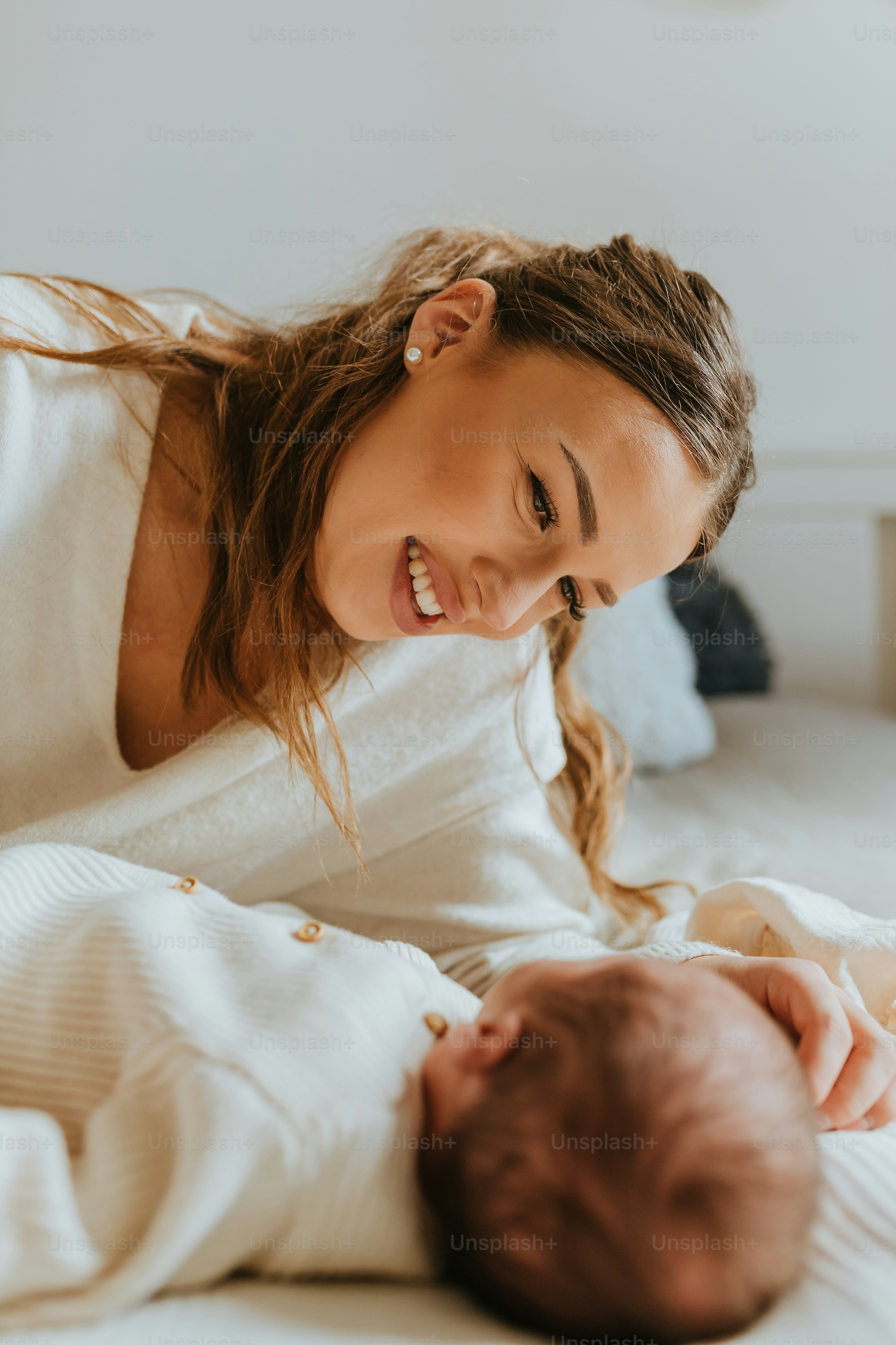uma mulher sorri enquanto segura um bebê