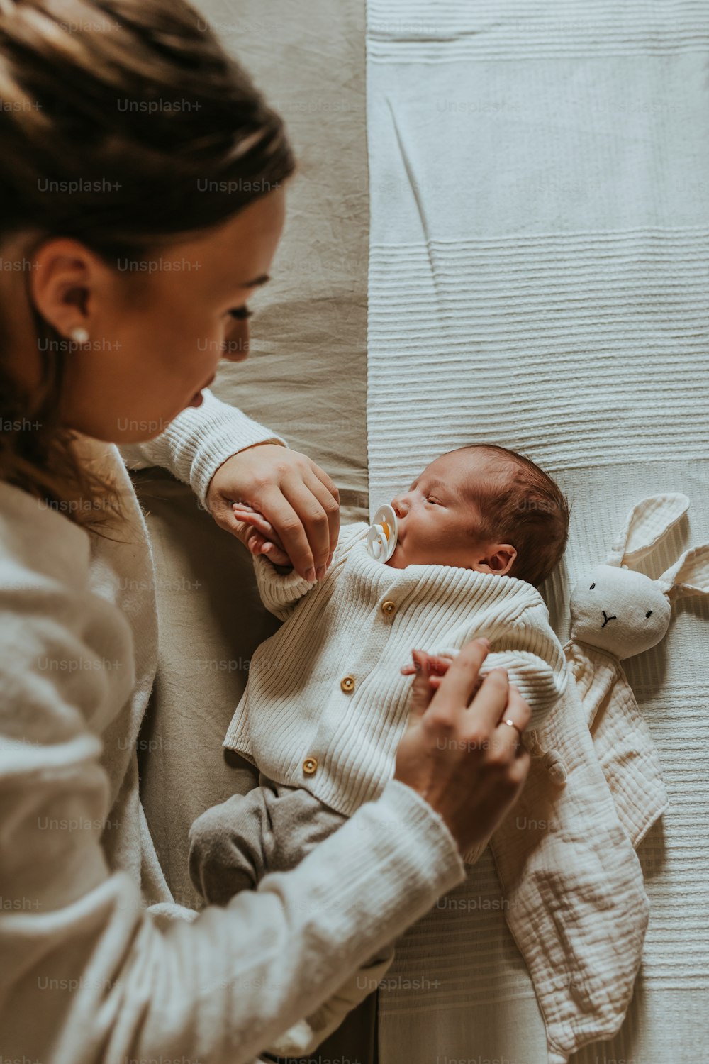 a woman holding a baby on a bed