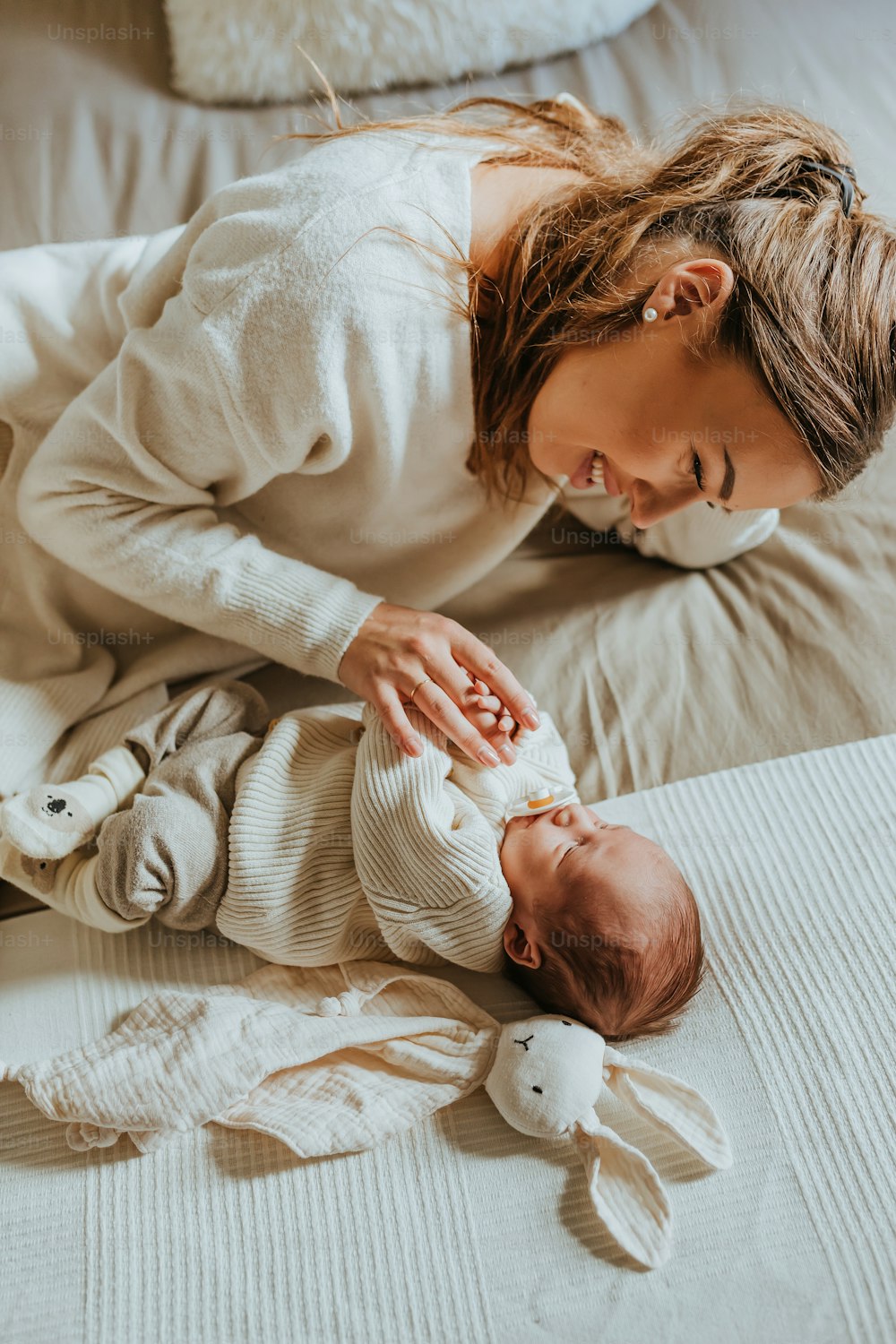 a woman laying on a bed holding a baby