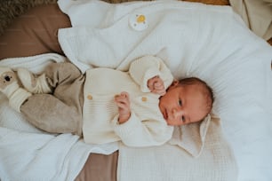 a baby is laying on a blanket on a bed