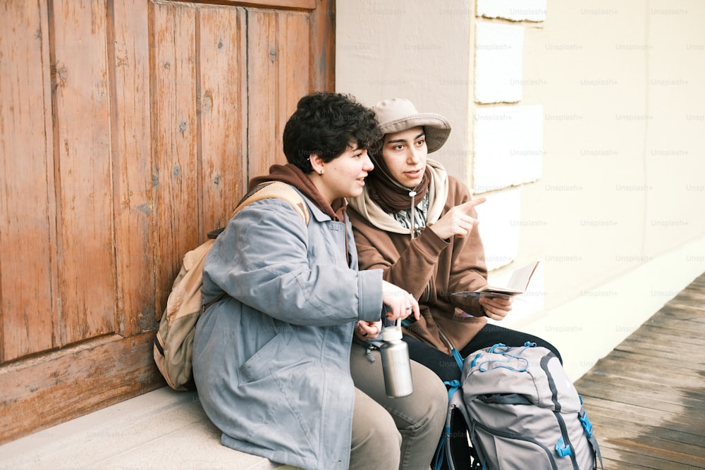 a couple of people sitting on the side of a building