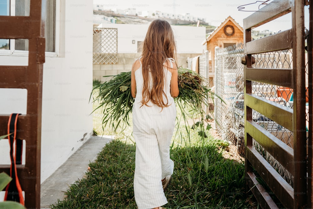 a woman in a white jumpsuit walking away from the camera