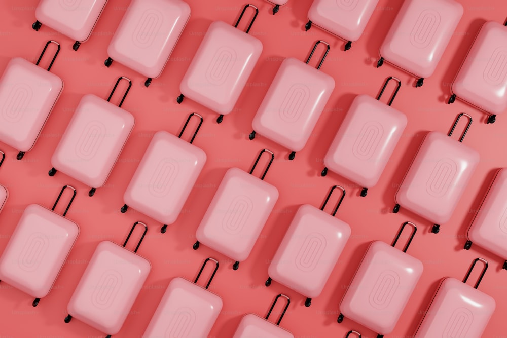 Un mazzo di valigie rosa allineate su uno sfondo rosa