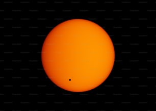 uma bola laranja brilhante de sol no céu escuro