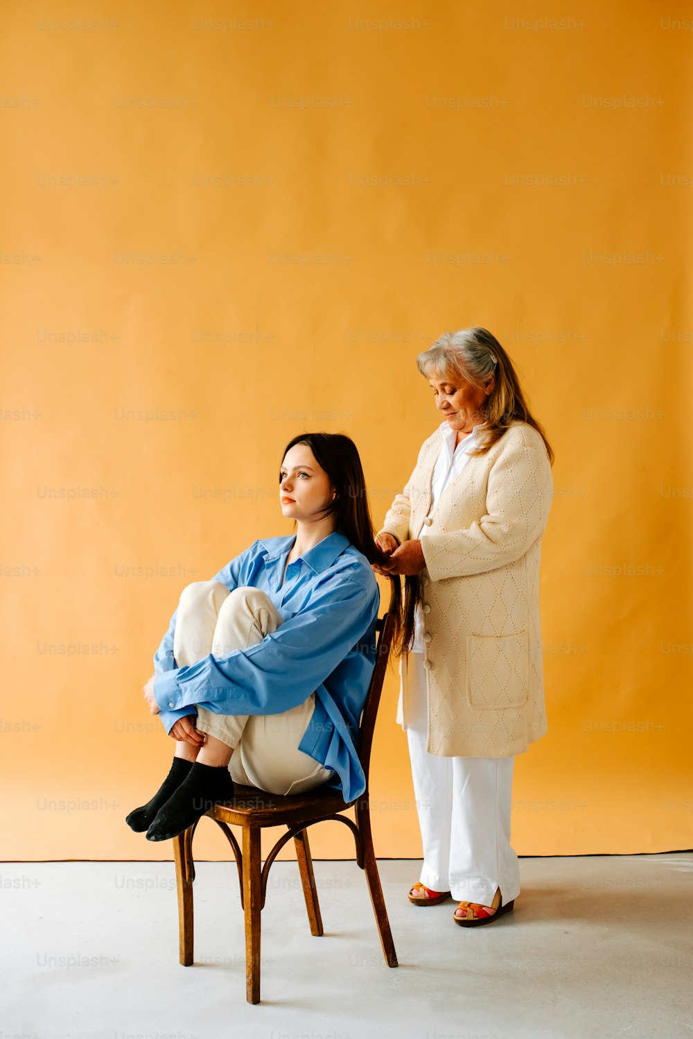 a woman sitting in a chair next to another woman