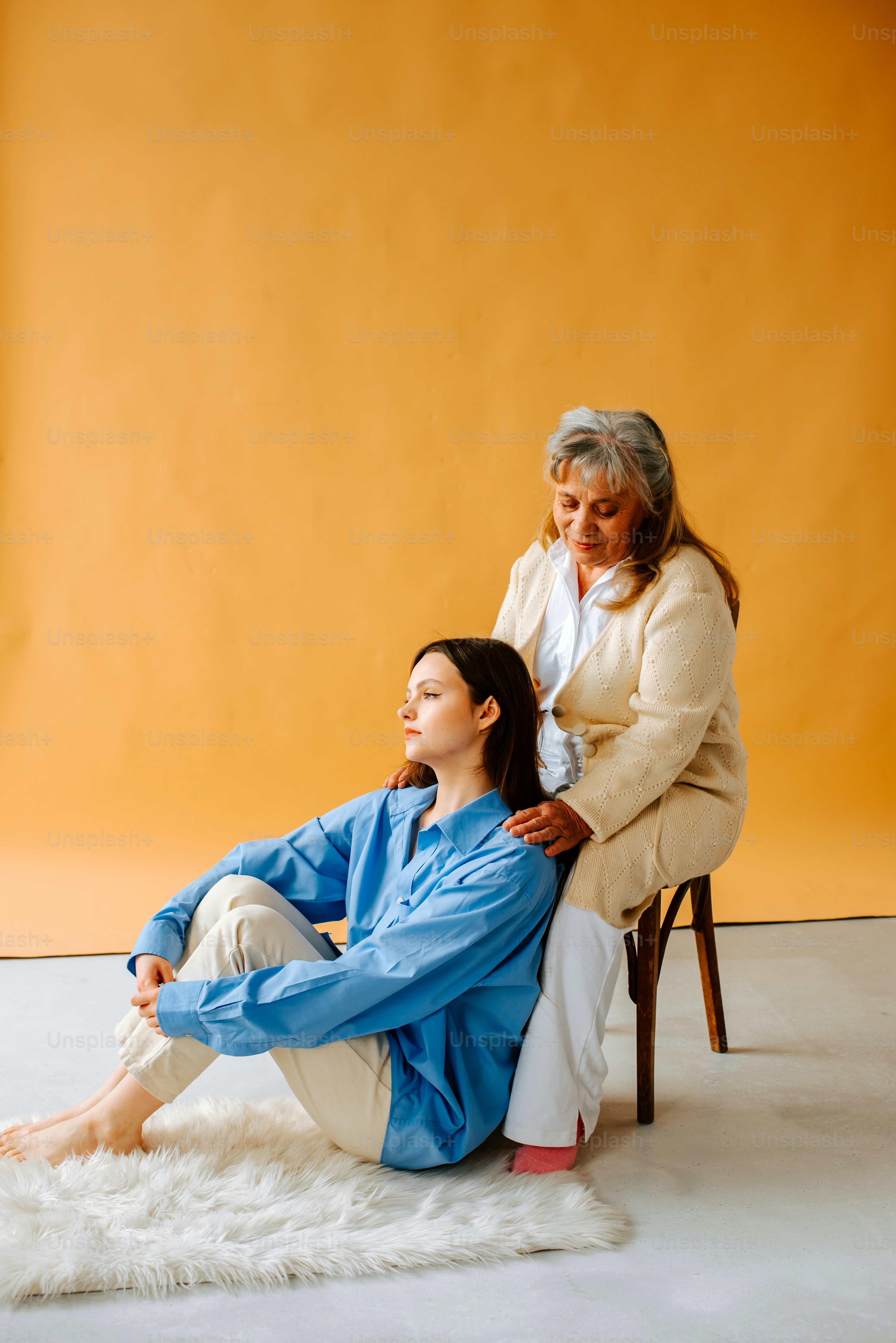 Una mujer sentada encima de una silla junto a una mujer
