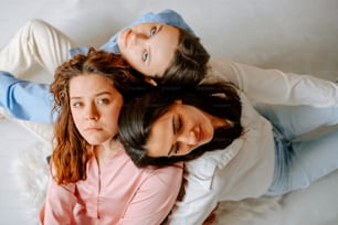 three women laying on the ground with their arms around each other