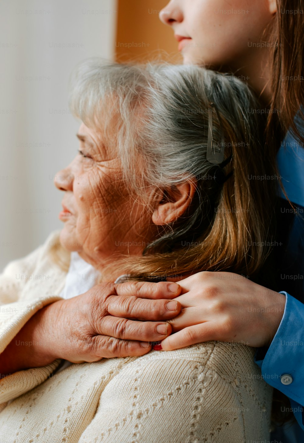 a woman is holding the arm of an older woman