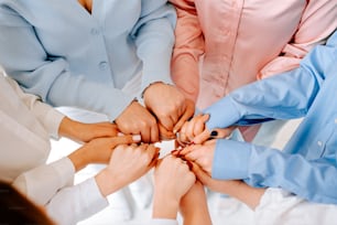 a group of people putting their hands together