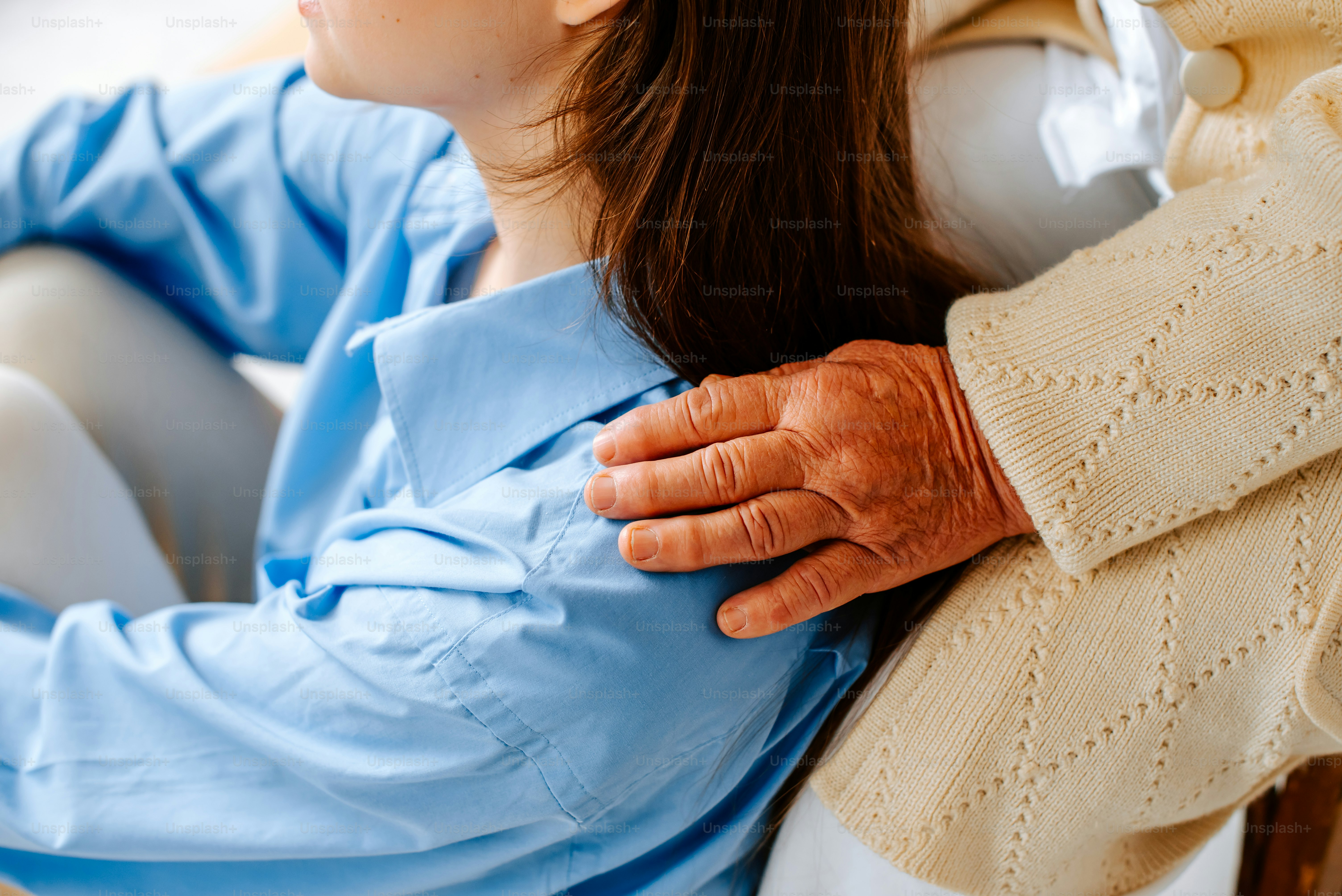 Une femme assise sur une chaise avec son bras autour de l’épaule d’un homme