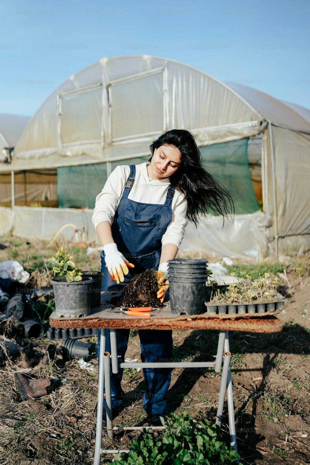 a woman in an apron is working in a garden