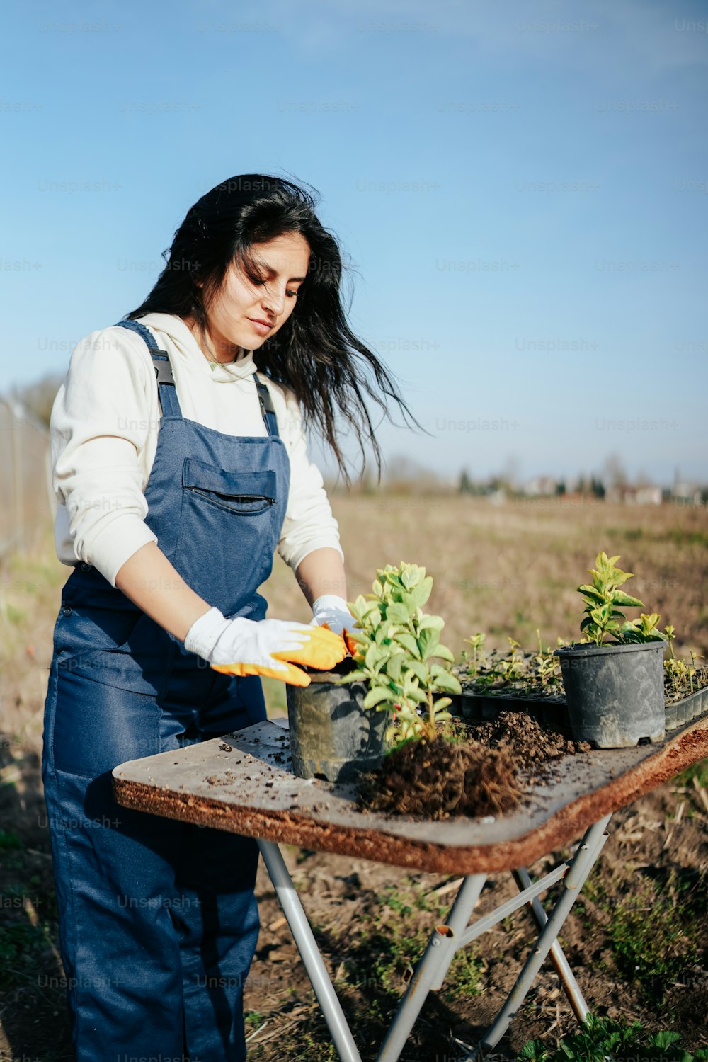 a woman in a blue apron is gardening