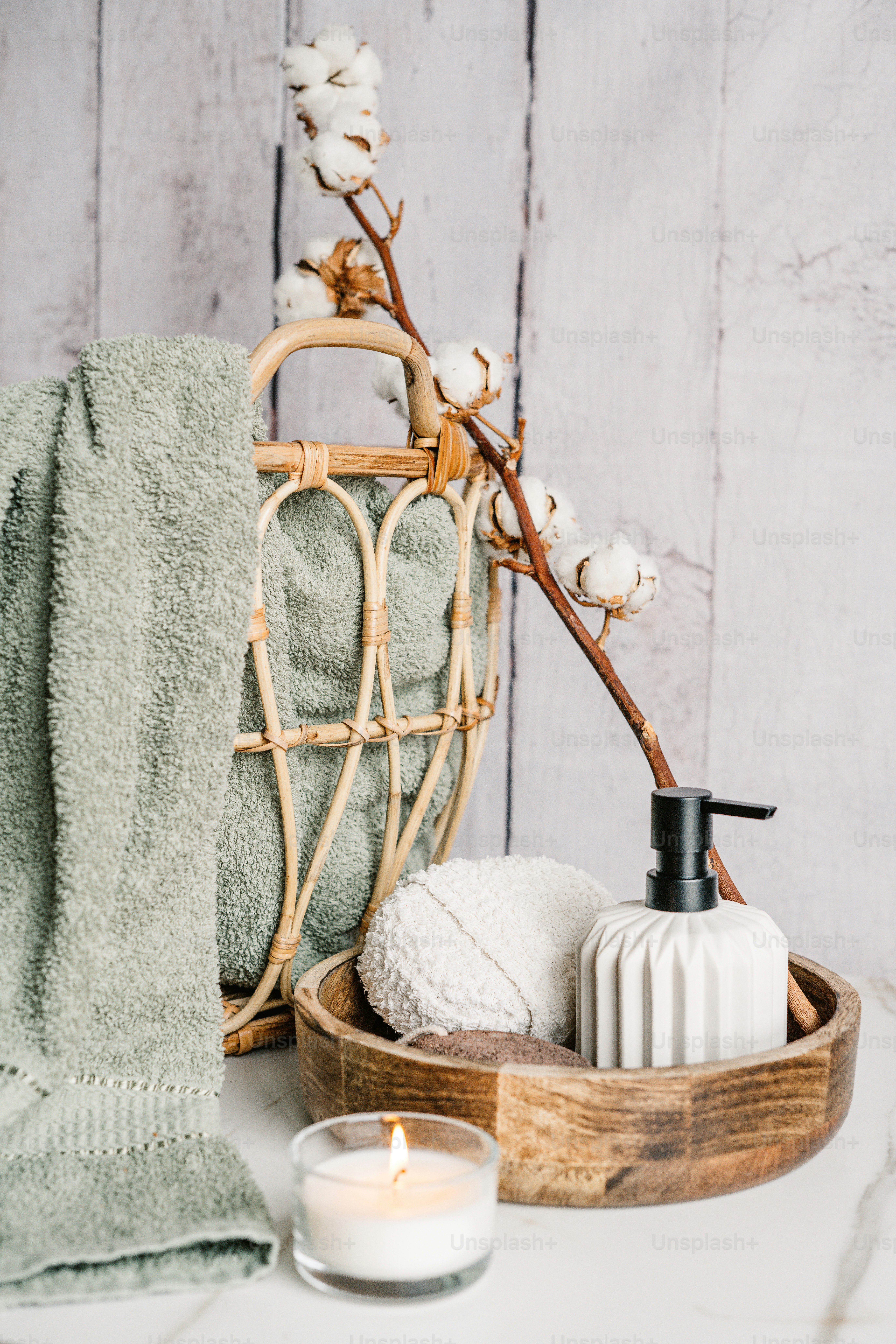 una canasta de jabones y una vela sobre una mesa