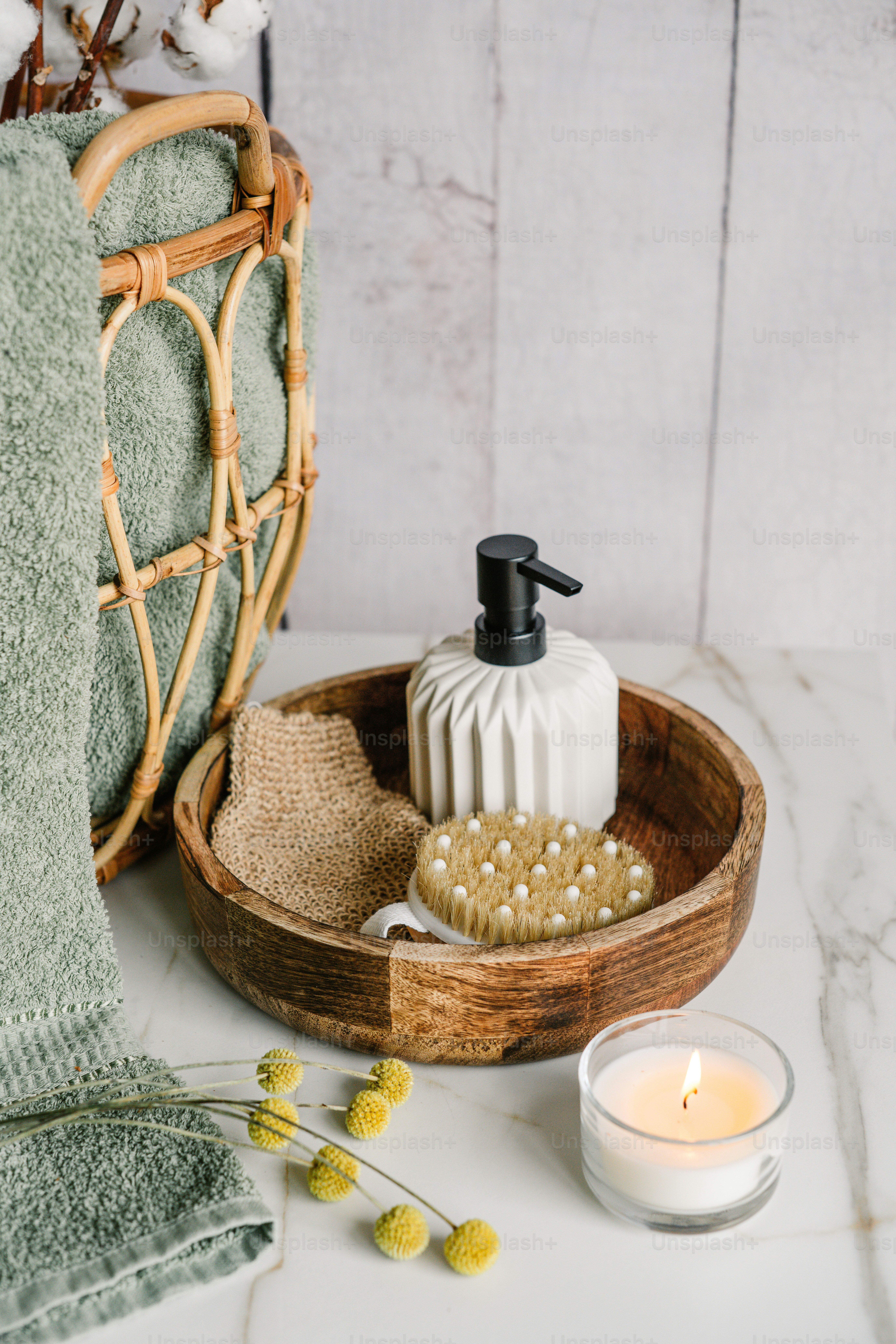 タオルの横に石鹸ディスペンサーが付いた木製のボウル