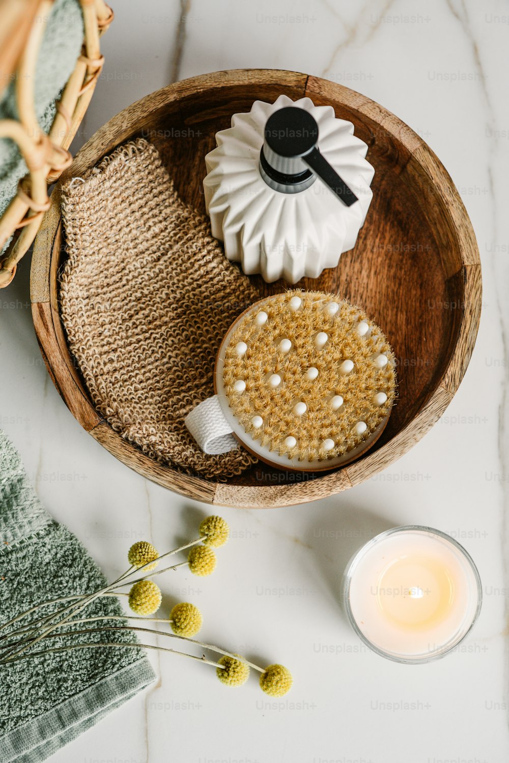 a wooden bowl filled with a cupcake next to a candle