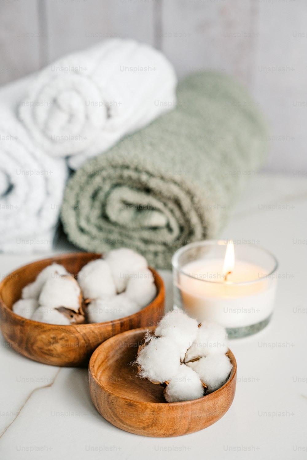 a couple of bowls filled with cotton next to a candle