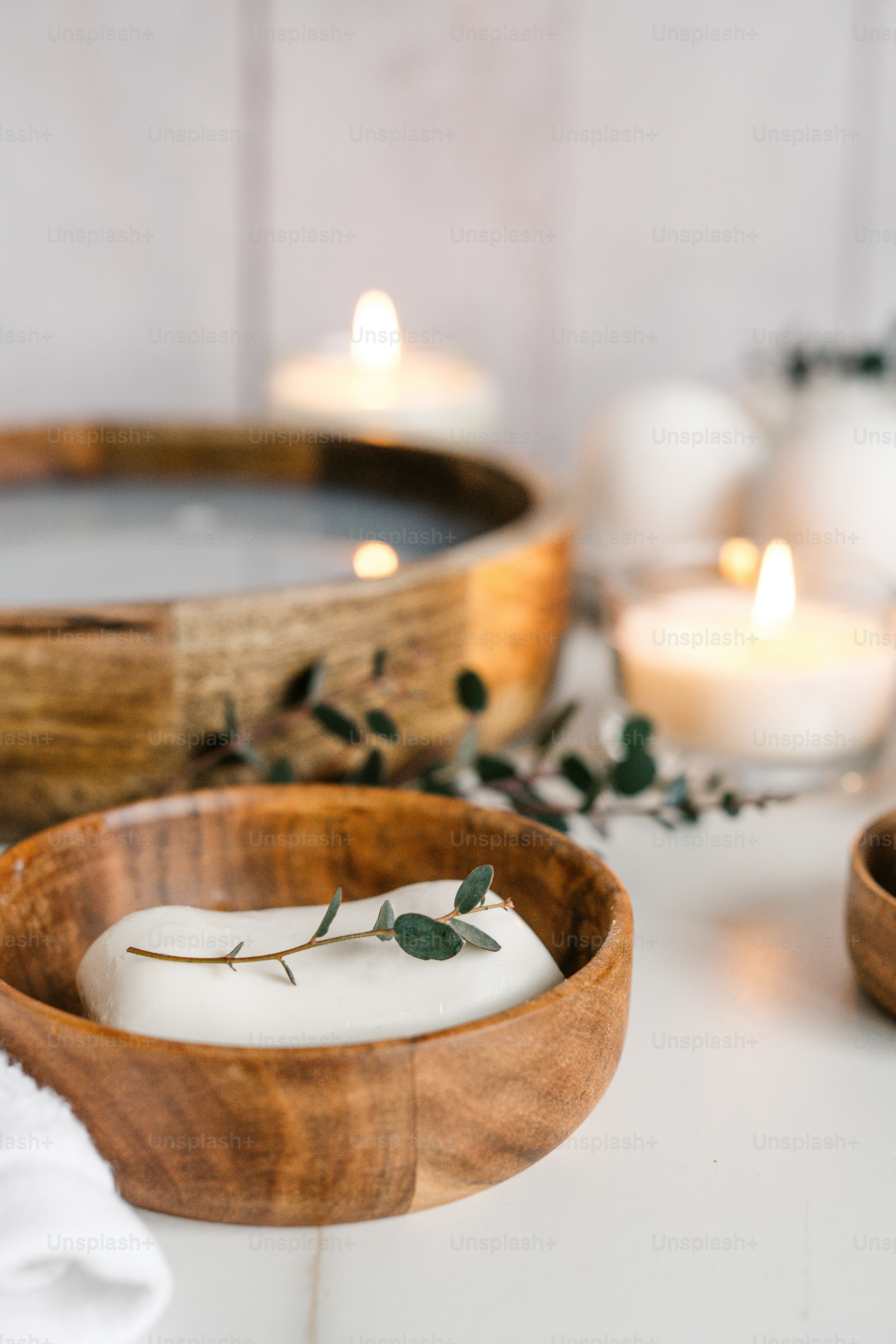 他のろうそくの隣にろうそくで満たされた木製のボウル