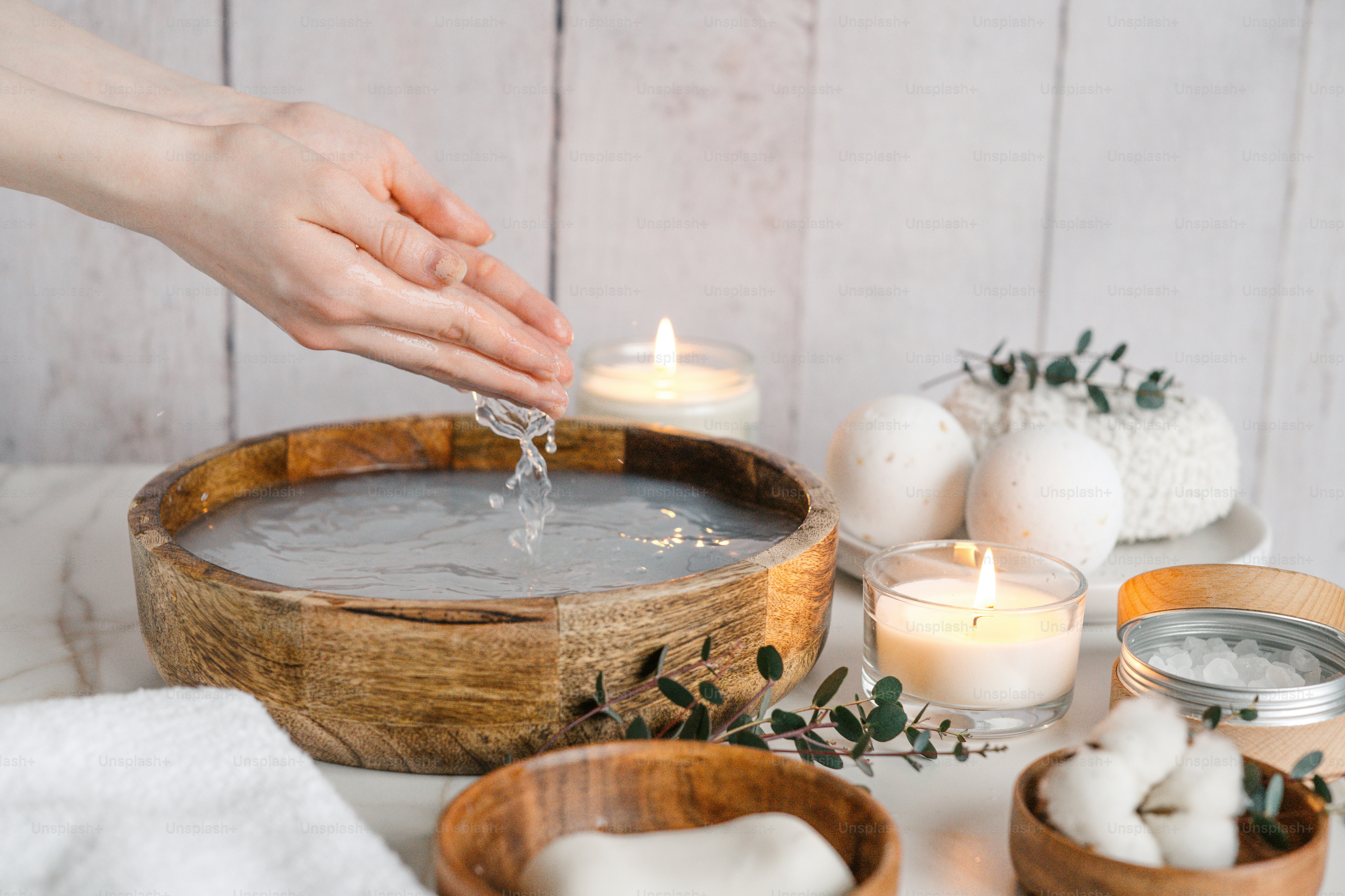 a person pouring water into a wooden bowl