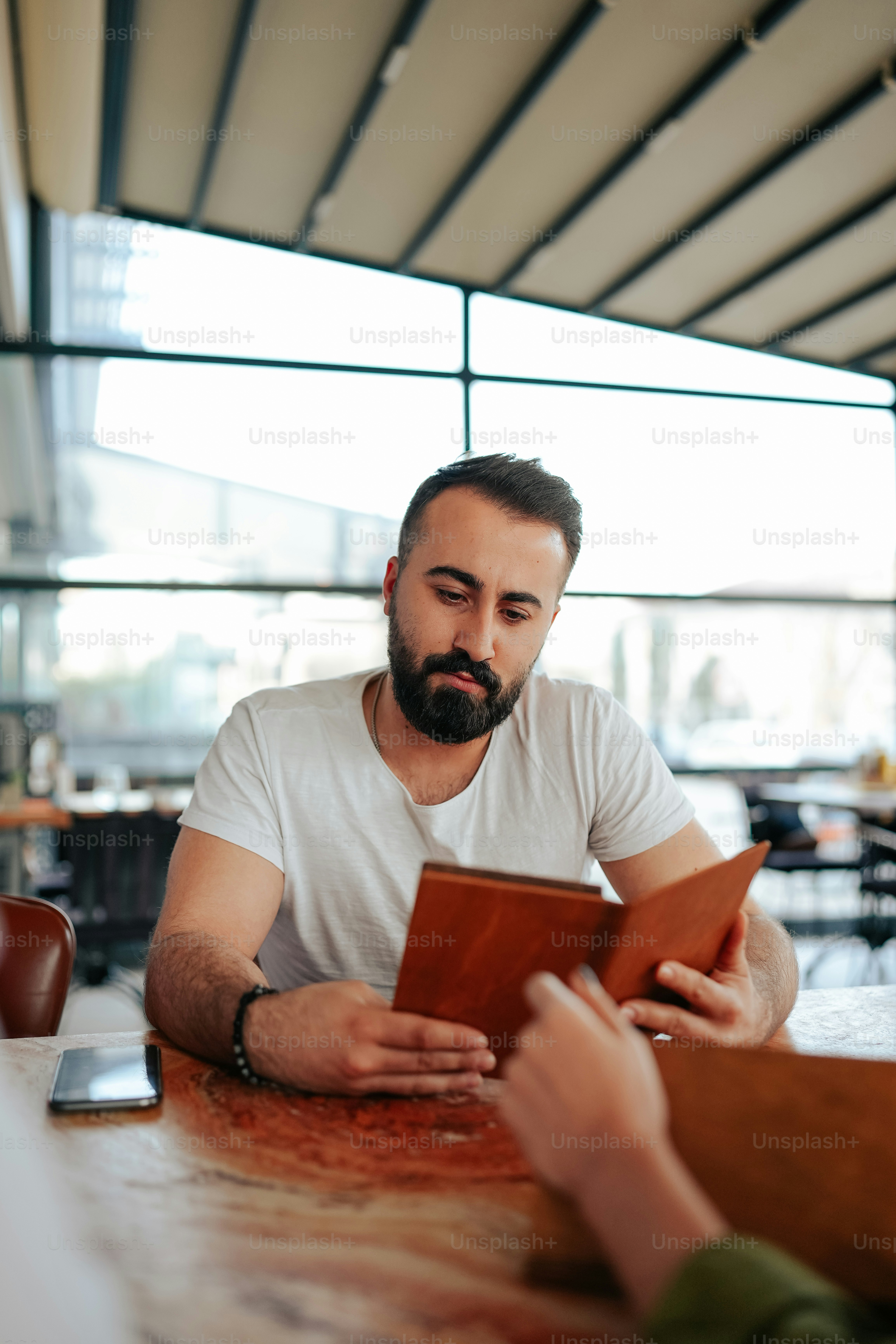 a man sitting at a table looking at a book