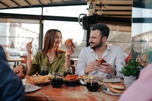 a man and a woman sitting at a table eating food