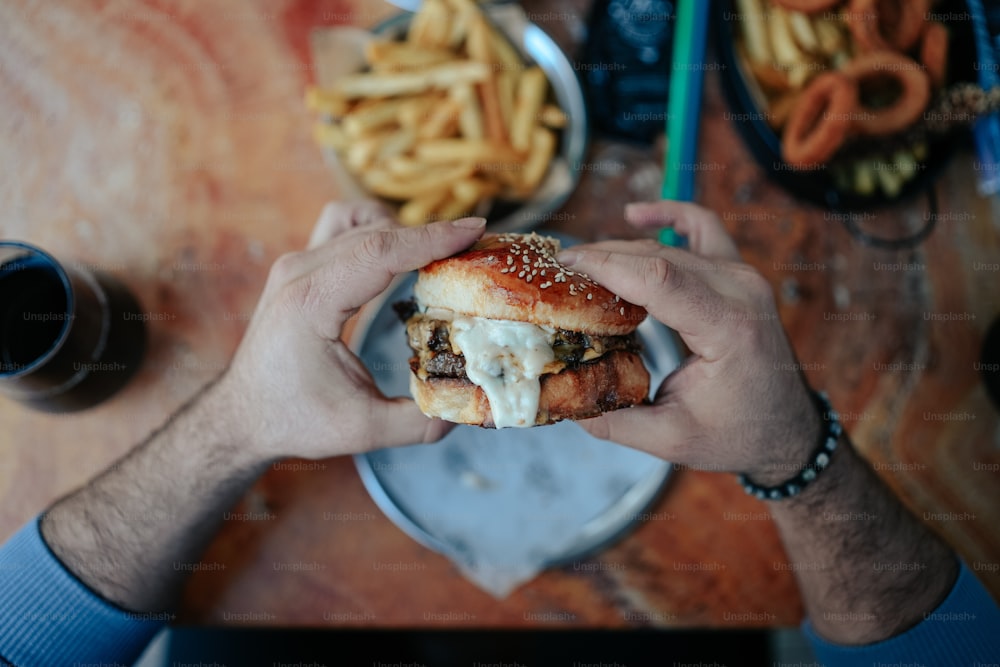 a man is holding a hamburger in his hands