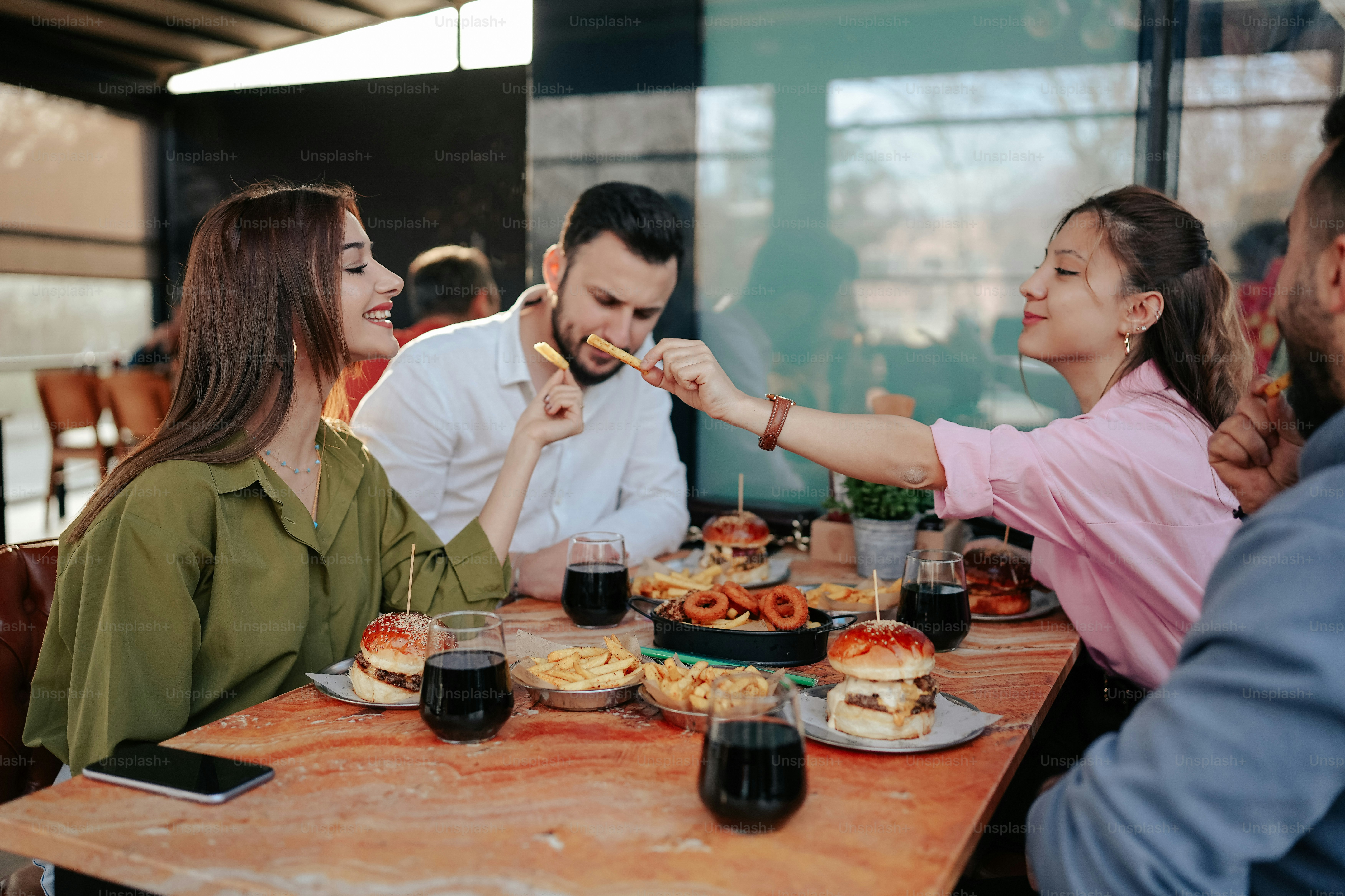 a group of people sitting around a table eating food