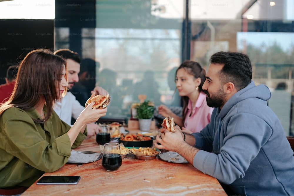 Un gruppo di persone sedute a un tavolo che mangiano pizza