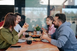 Eine Gruppe von Leuten, die an einem Tisch sitzen und Pizza essen