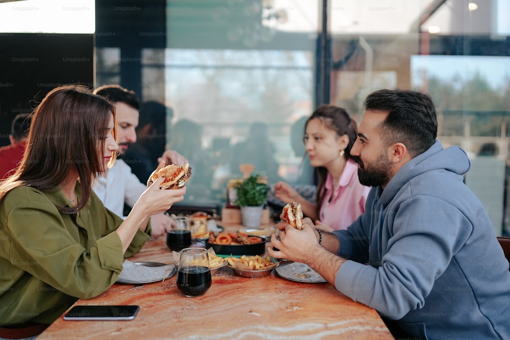 a group of people sitting at a table eating pizza