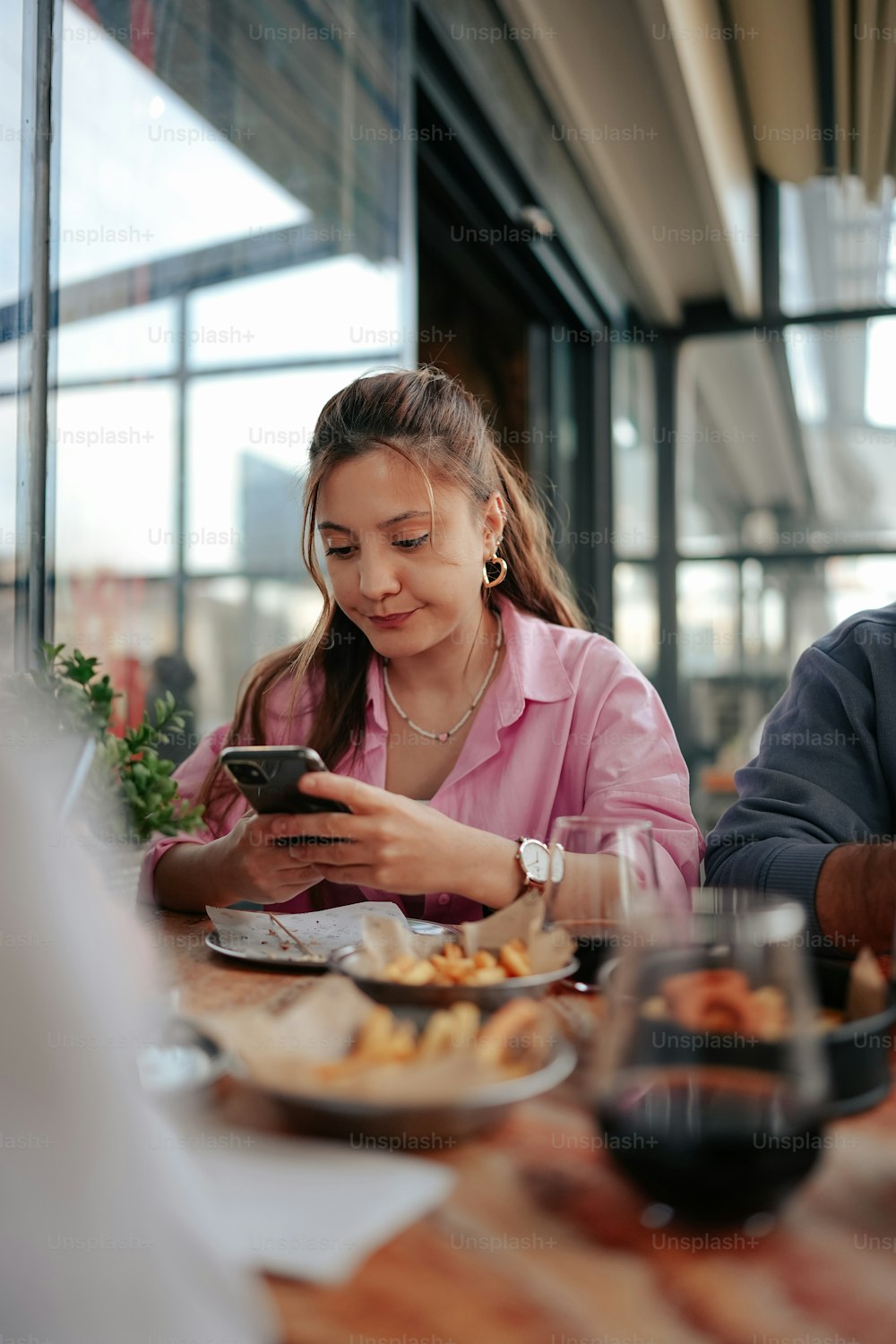 a man and a woman sitting at a table looking at a cell phone