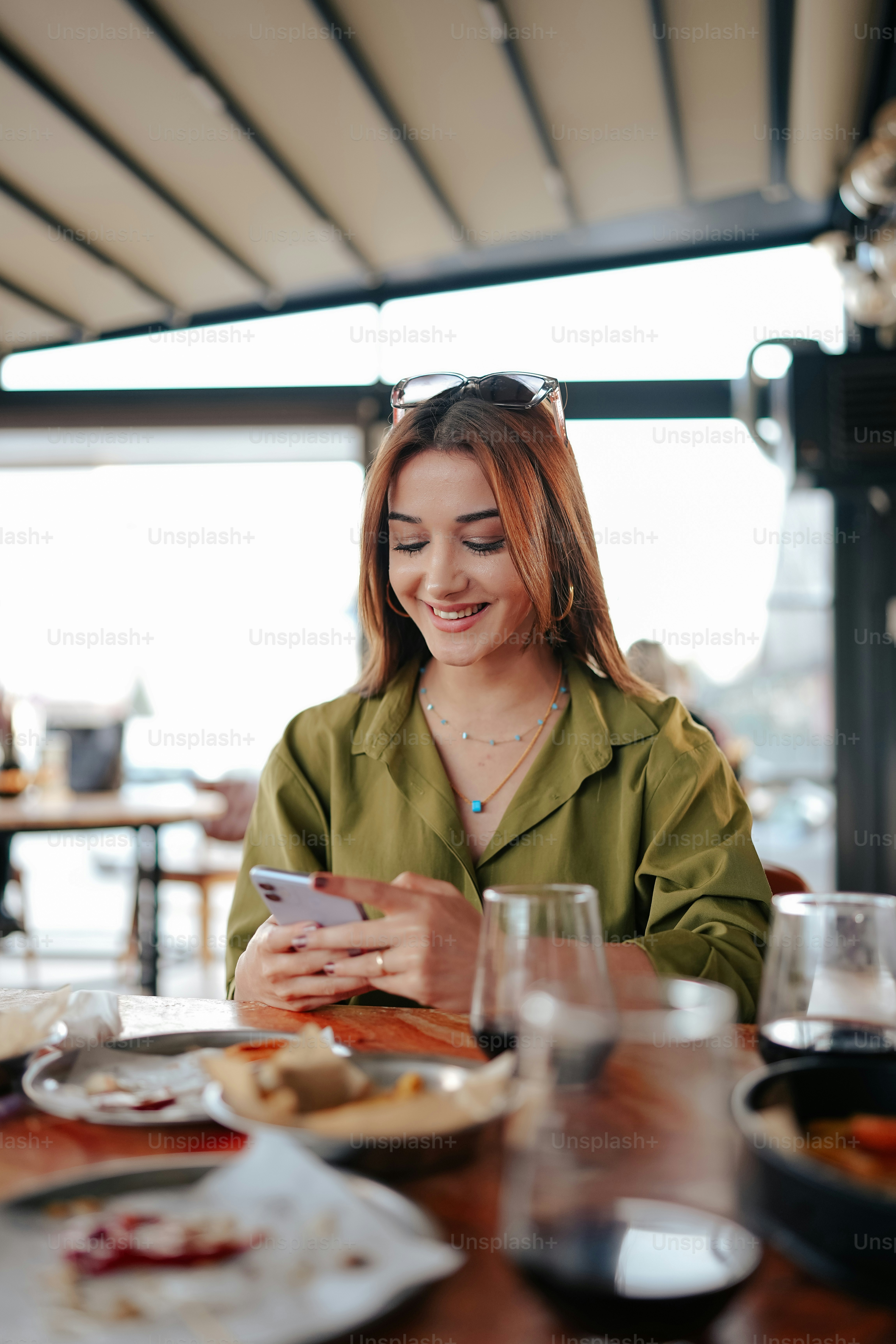 a woman sitting at a table looking at her cell phone