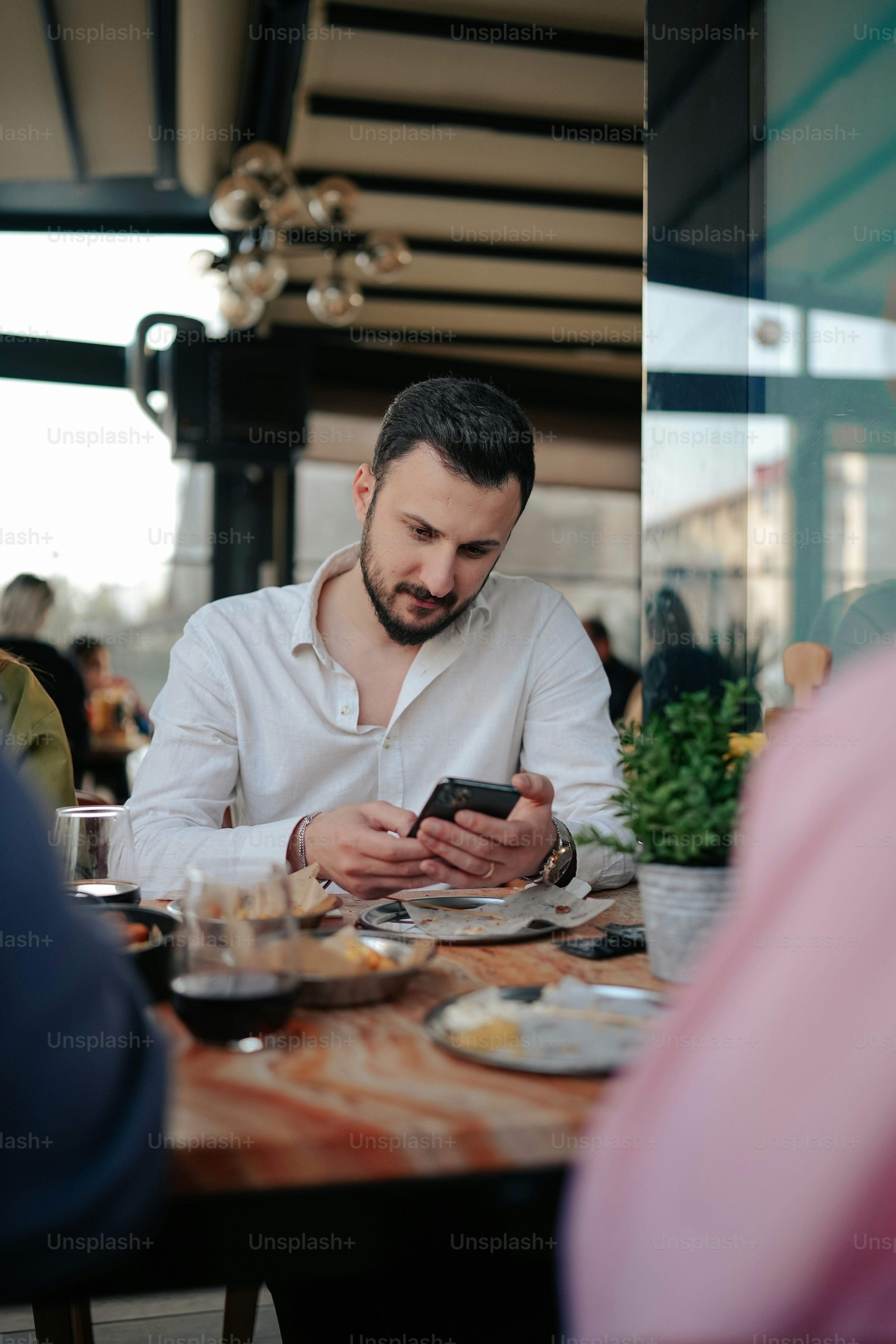 a man sitting at a table looking at his cell phone