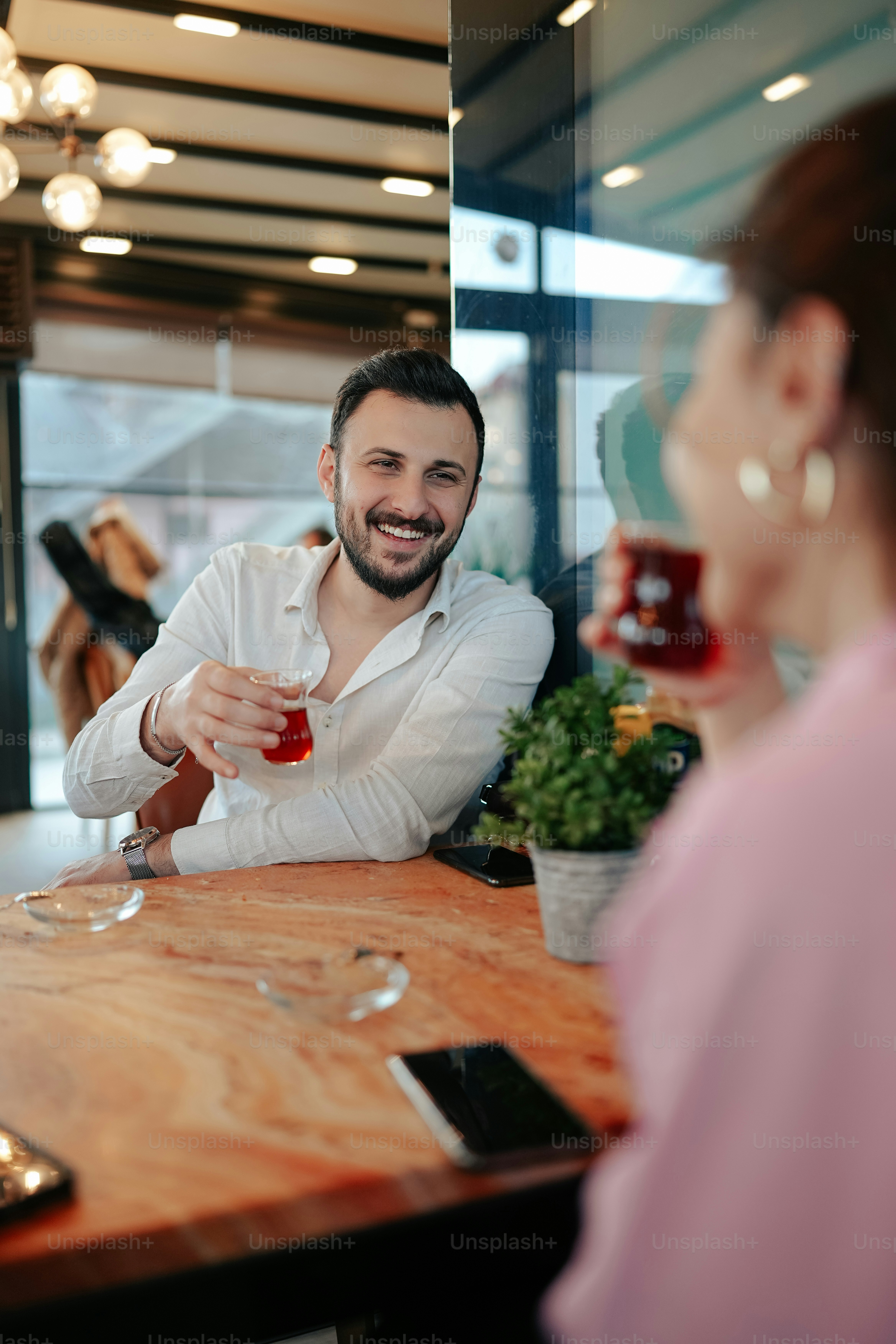 a man sitting at a table with a glass of wine