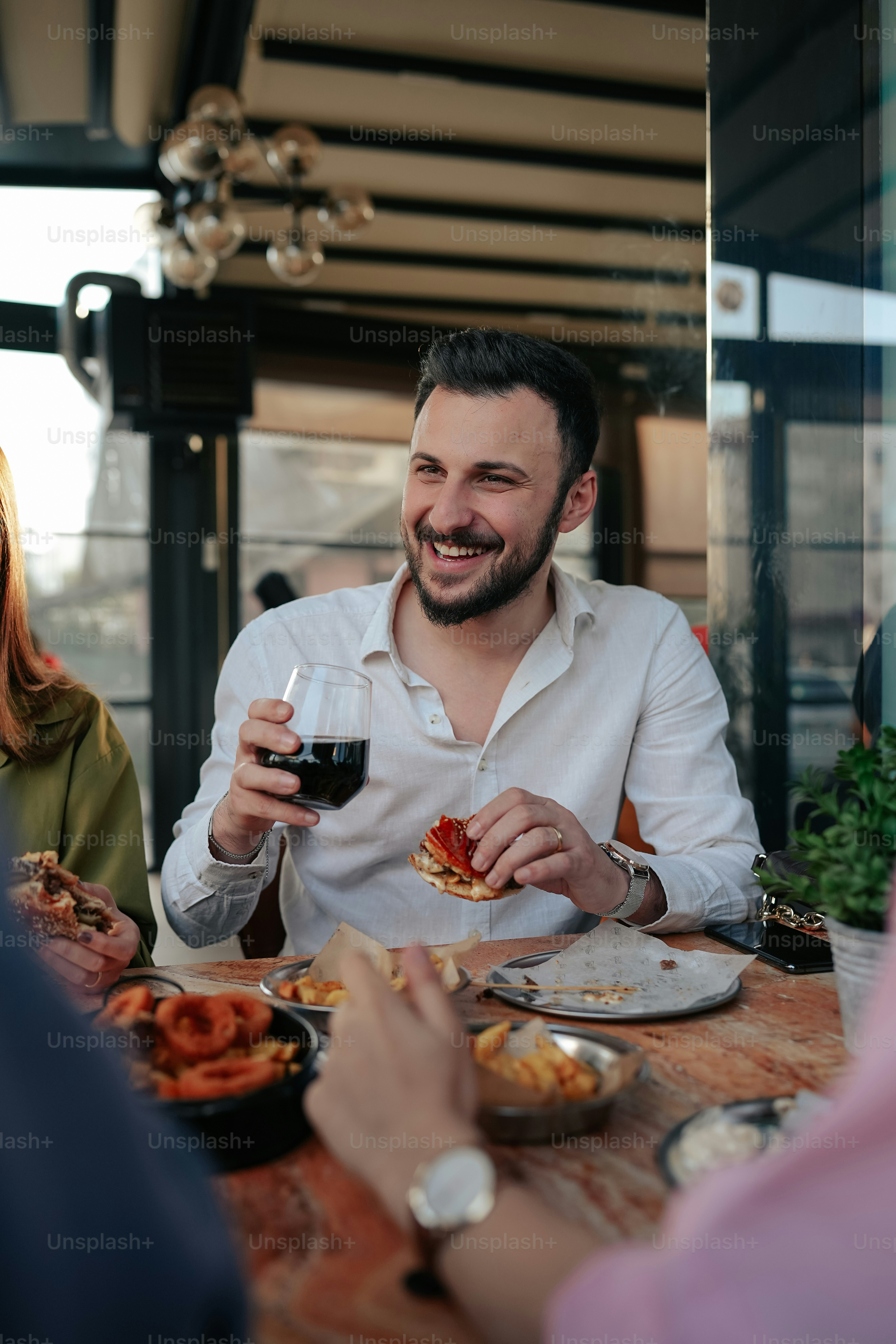 a man sitting at a table with a glass of wine