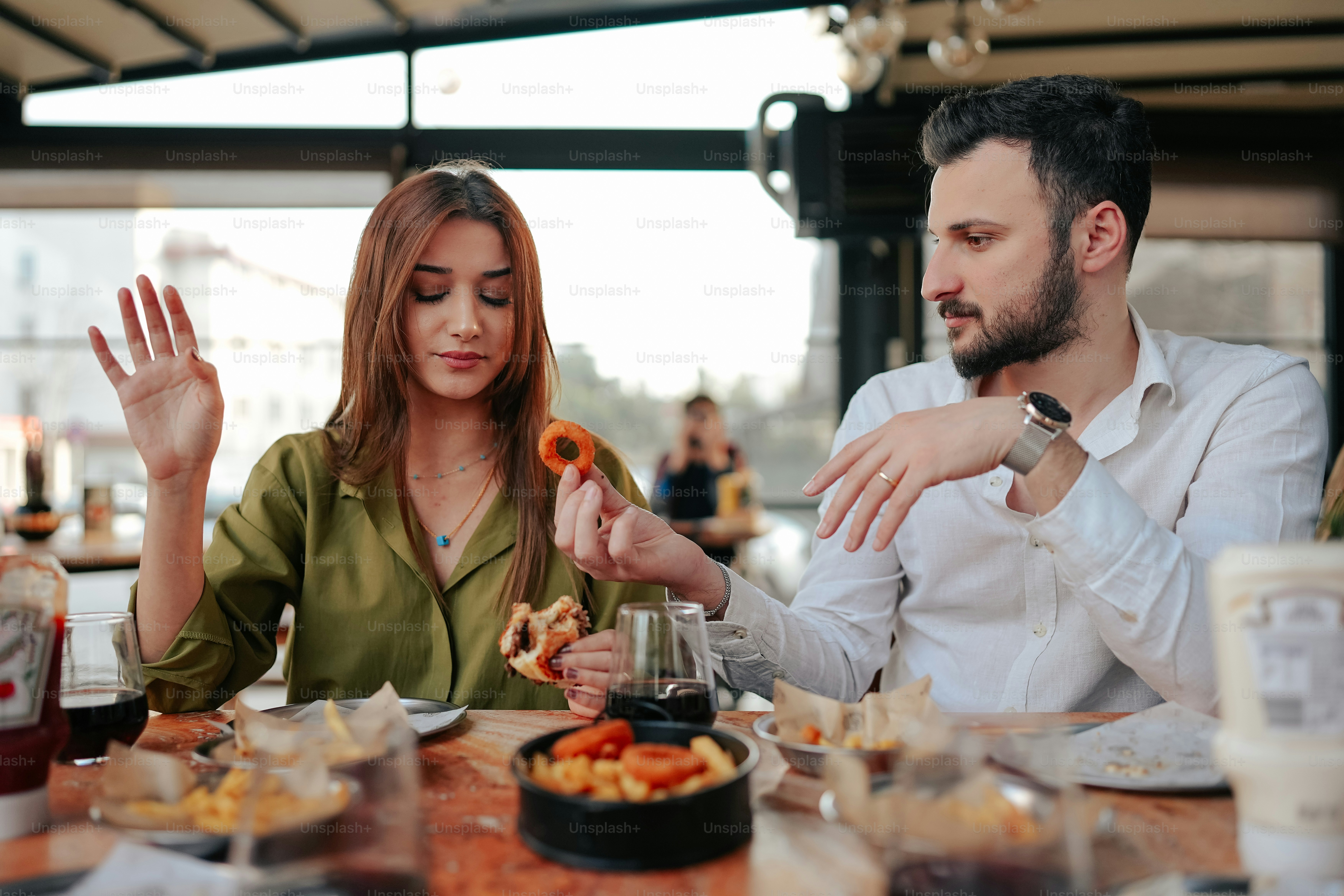 a man and a woman sitting at a table eating food