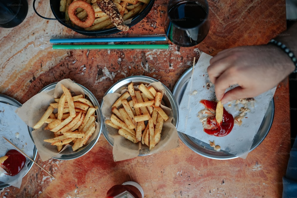 two bowls of french fries with ketchup on a table
