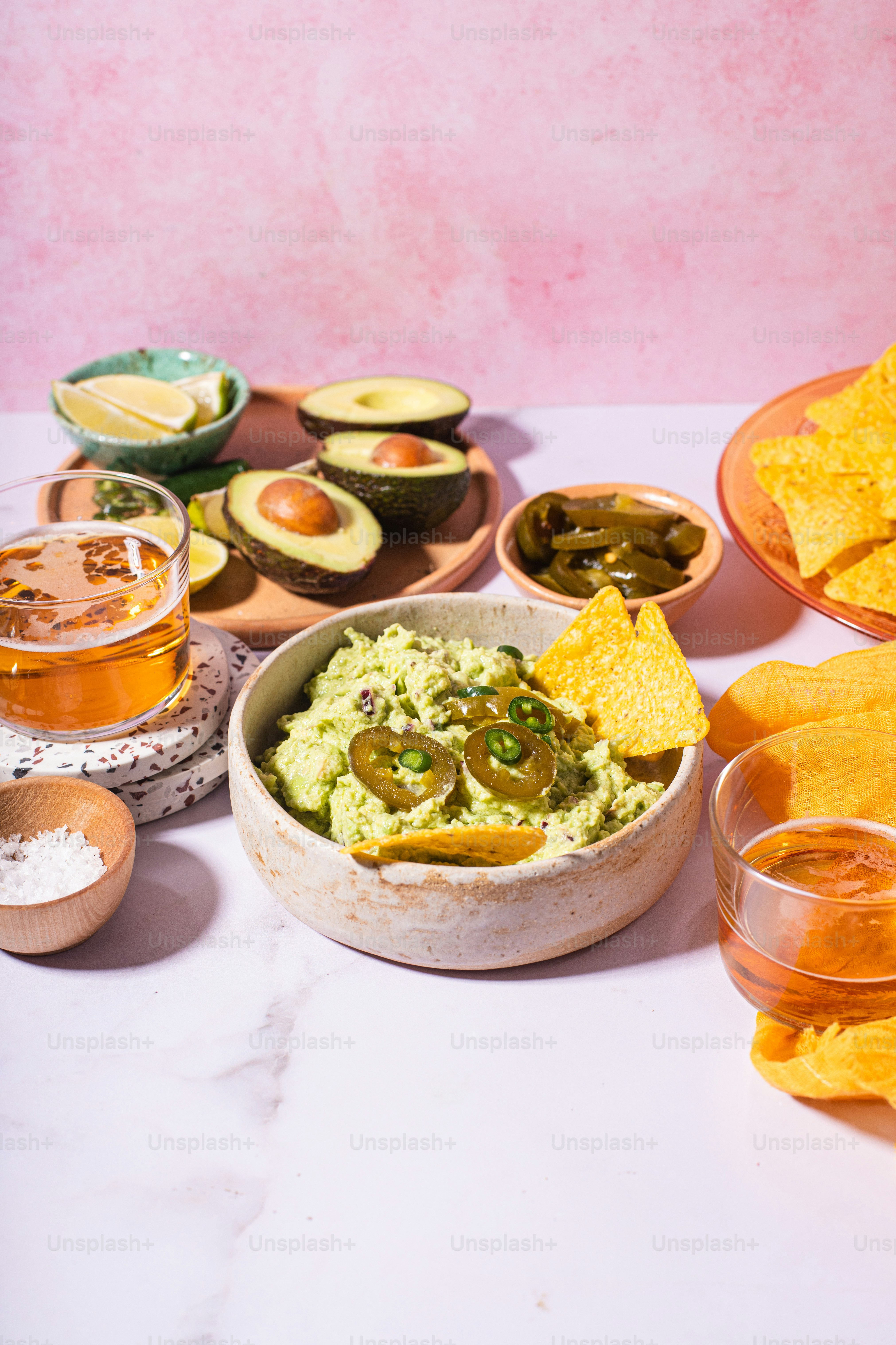 uma tigela de guacamole, chips de tortilha, salsa e