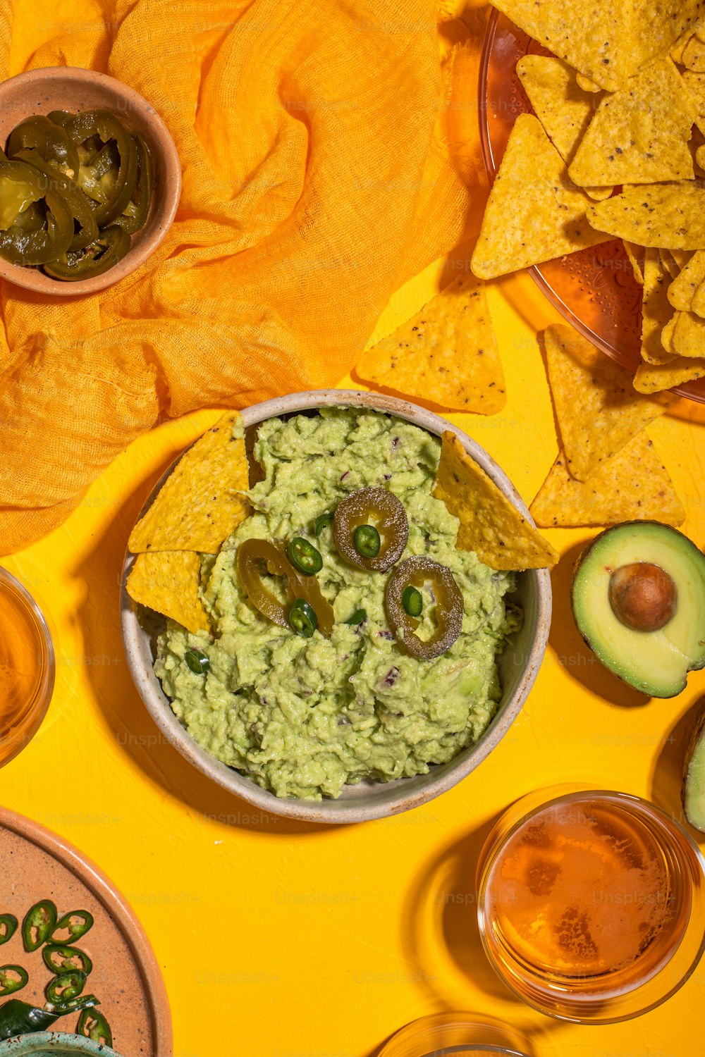 a bowl of guacamole surrounded by chips and salsa