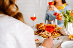 a woman sitting at a table with a glass of wine