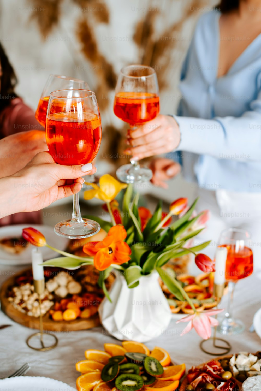 un groupe de personnes assises autour d’une table avec des verres à vin
