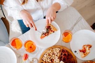 a person cutting a slice of pizza on a table