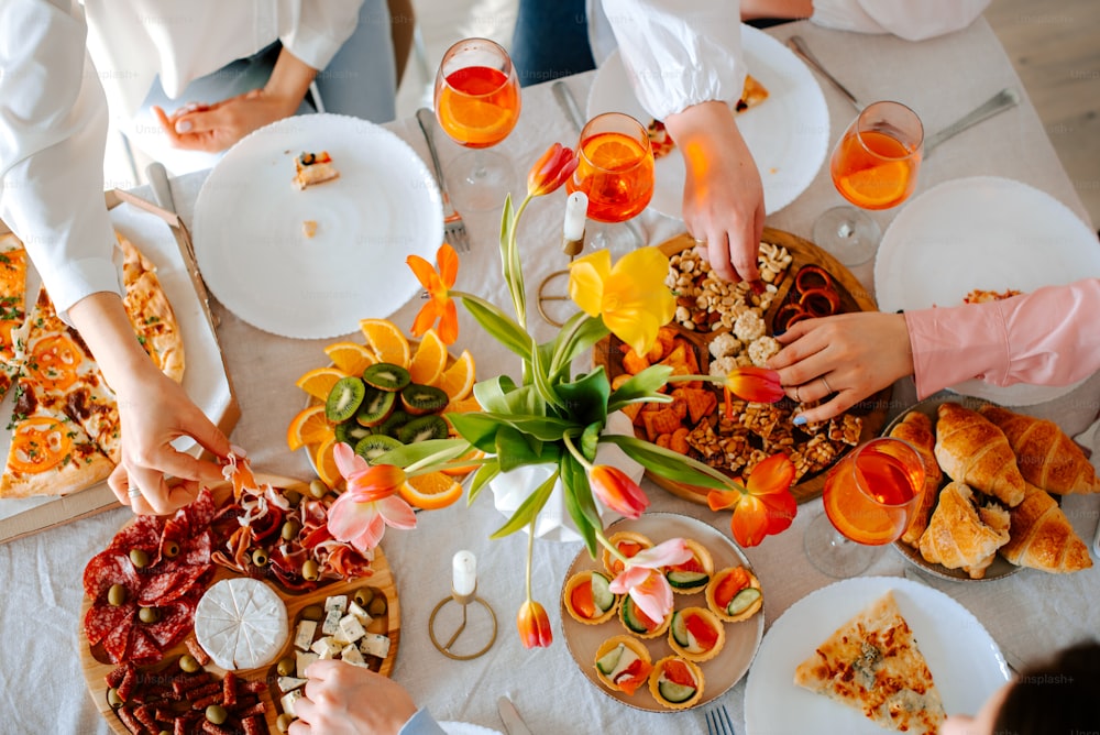 um grupo de pessoas sentadas ao redor de uma mesa com comida
