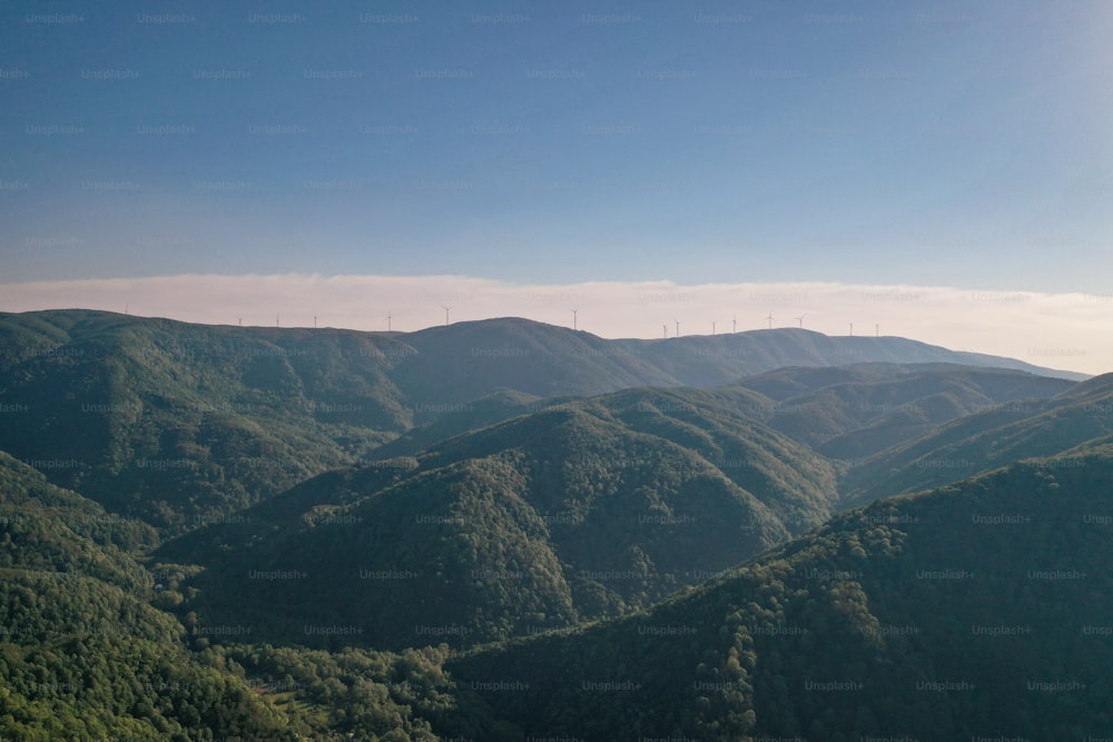 a view of a mountain range with wind mills in the distance