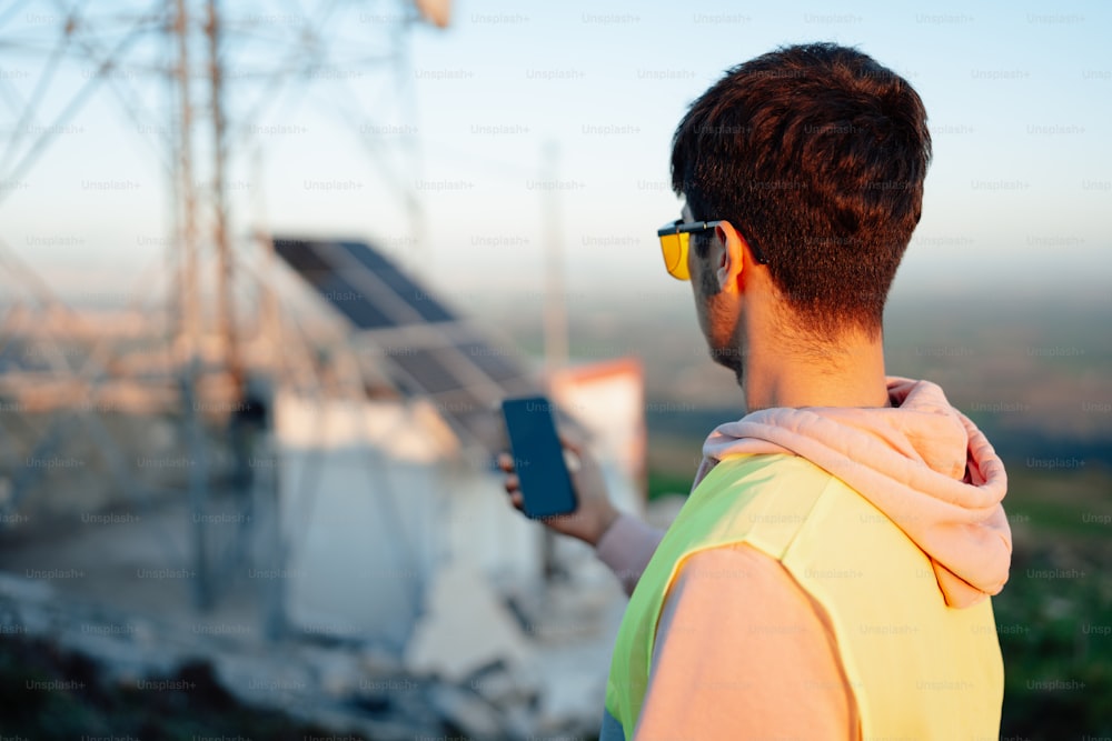 a man in a yellow vest holding a cell phone
