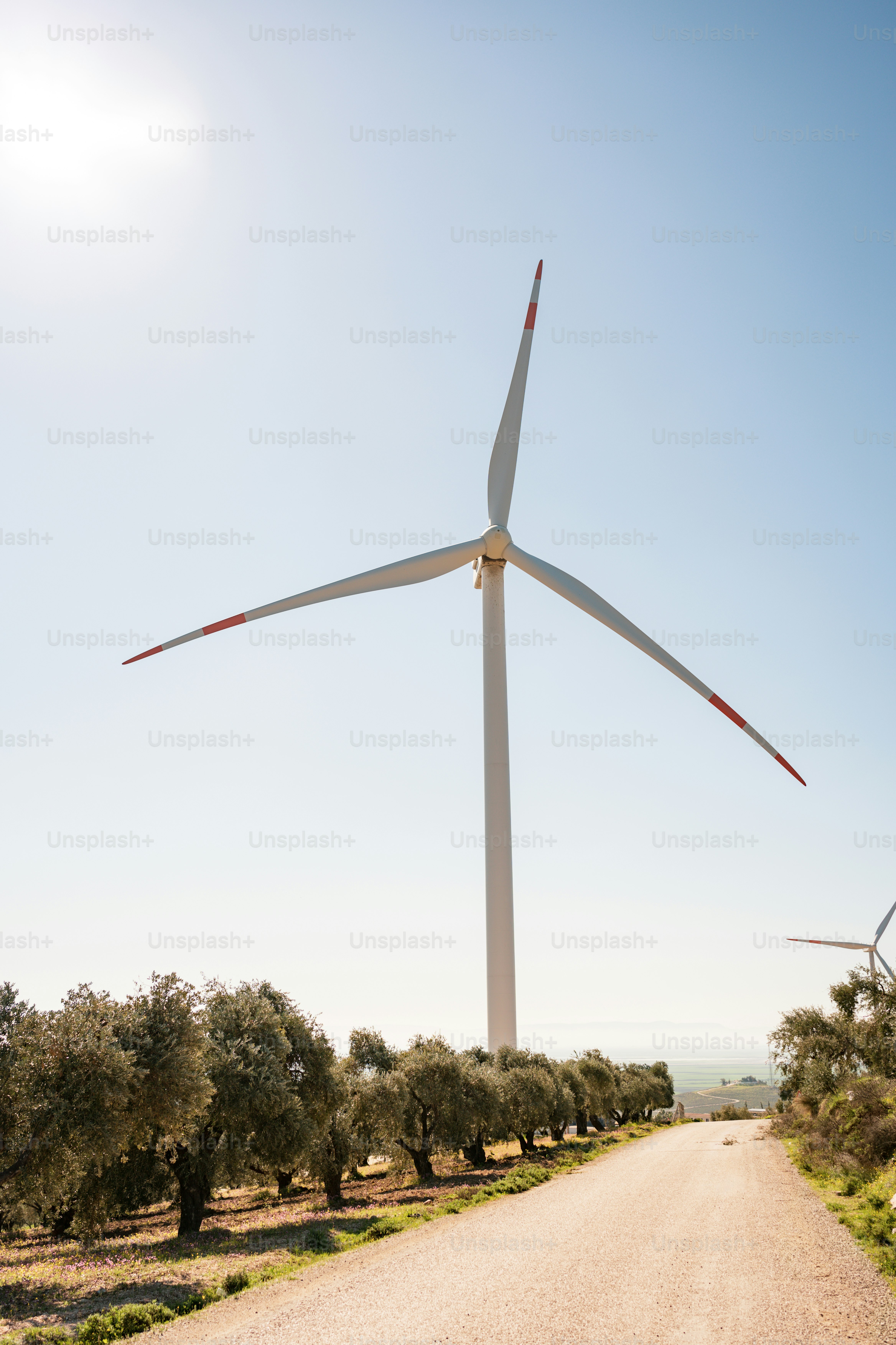 una turbina eolica sul lato di una strada sterrata